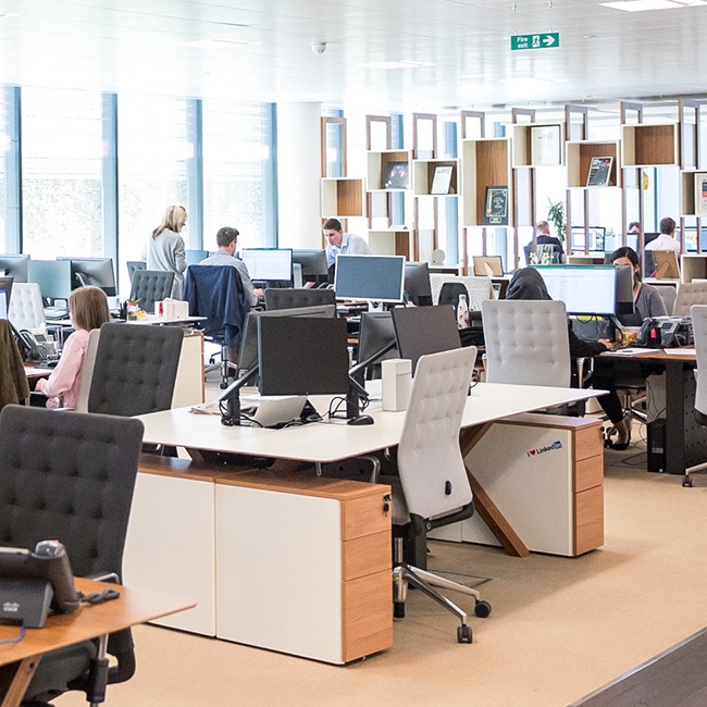 Un environnement de bureau ouvert avec de nombreuses personnes à leur poste de travail